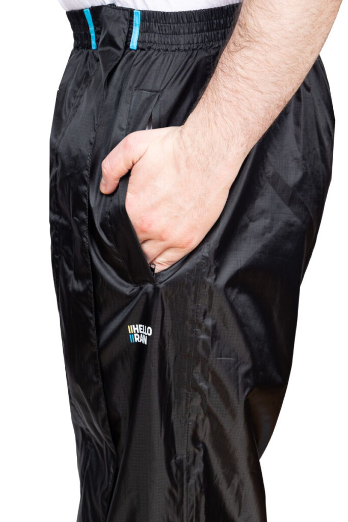 Hello Rain - innovatieve regenbroeken Product foto van de zijkant van de premium regenbroek waarbij de persoon gebruik maakt van de zijzakken.