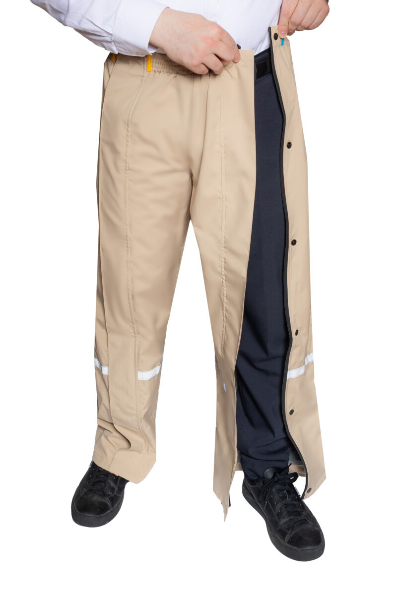 Product afbeelding van beige premium regenbroek waarbij de persoon de ritssluiting toe doet.