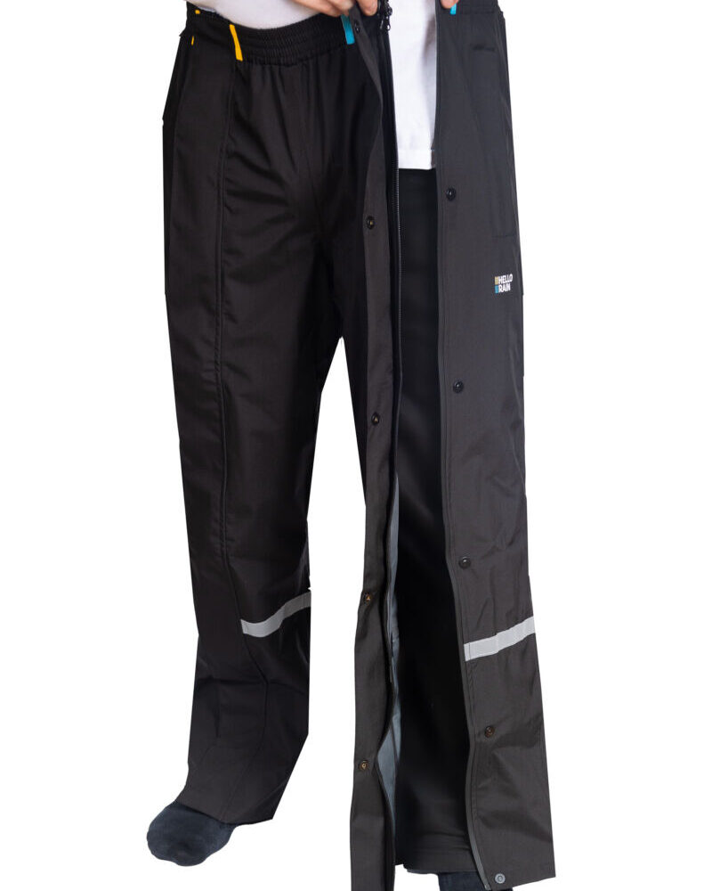 Product afbeelding van zwarte budget regenbroek waarbij de persoon de ritssluiting toe doet.