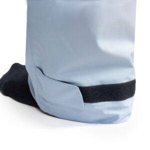 Close-up van licht blauwe premium regenbroek met zichtbaarheid op klittenband aan broekspijp.