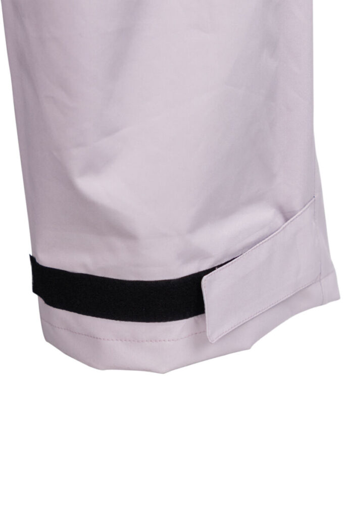 Close-up van grijze premium regenbroek met zichtbaarheid op klittenband aan broekspijp.